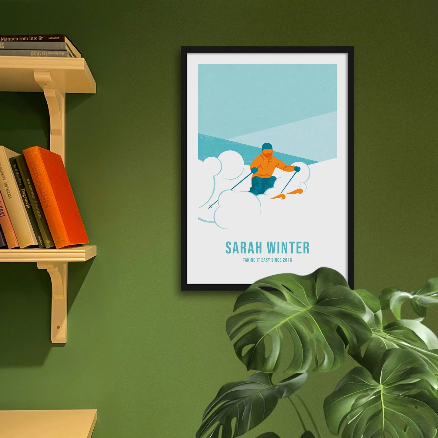Framed art print on a green wall beside shelves.