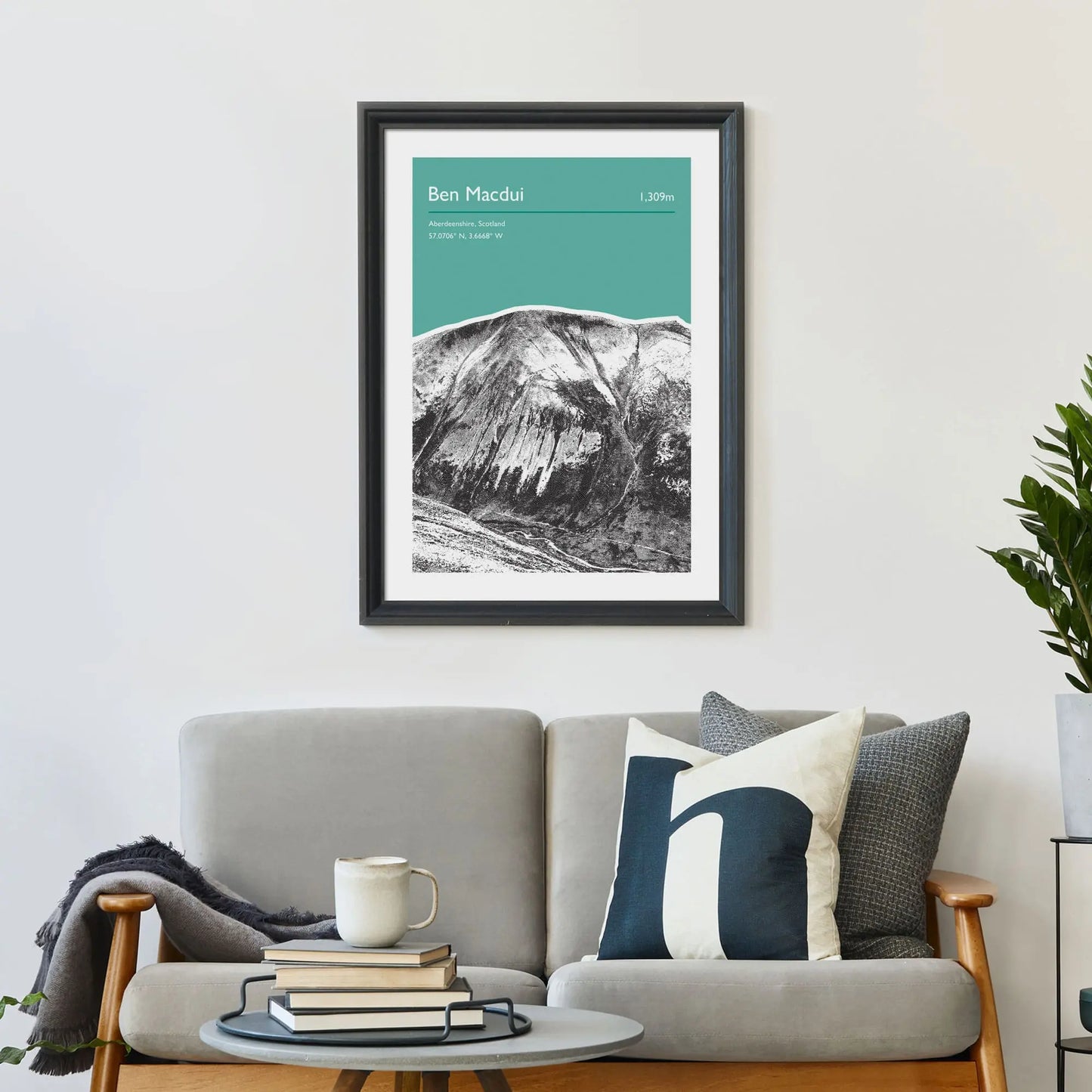 Print framed on wall above a sofa and cushions