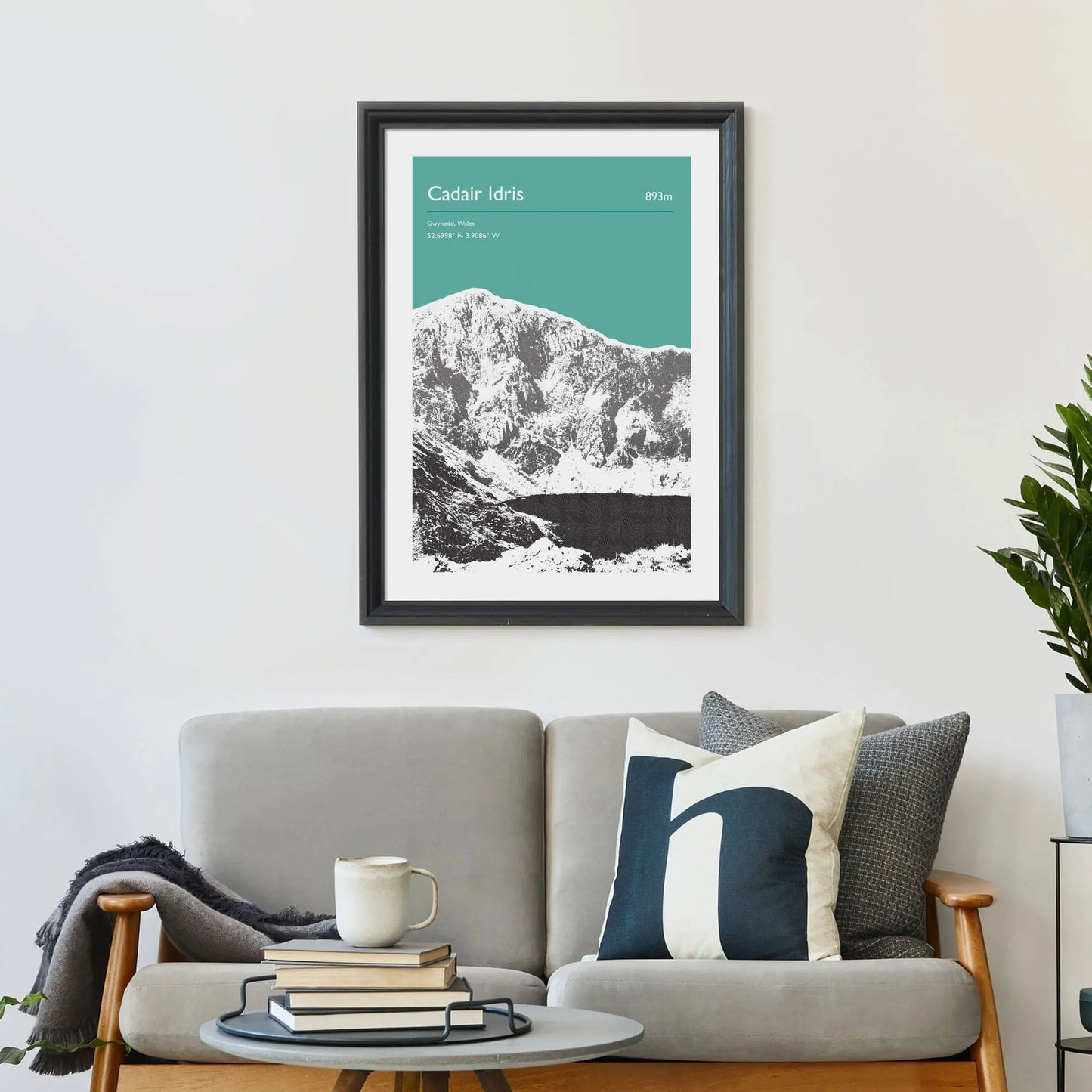 Print framed on wall above a sofa and cushions