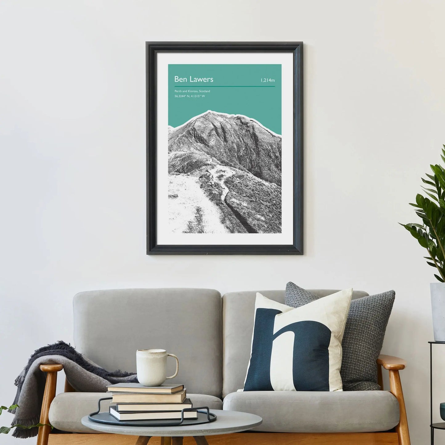 Print framed on wall above a sofa and cushions