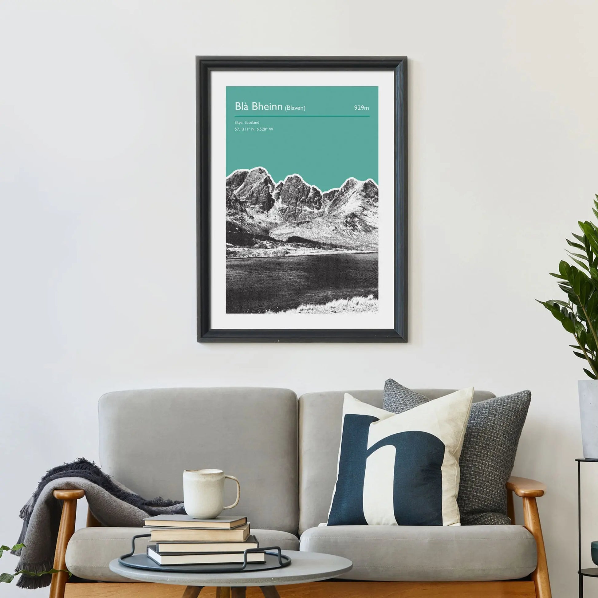 Print framed on wall above a sofa and cushions