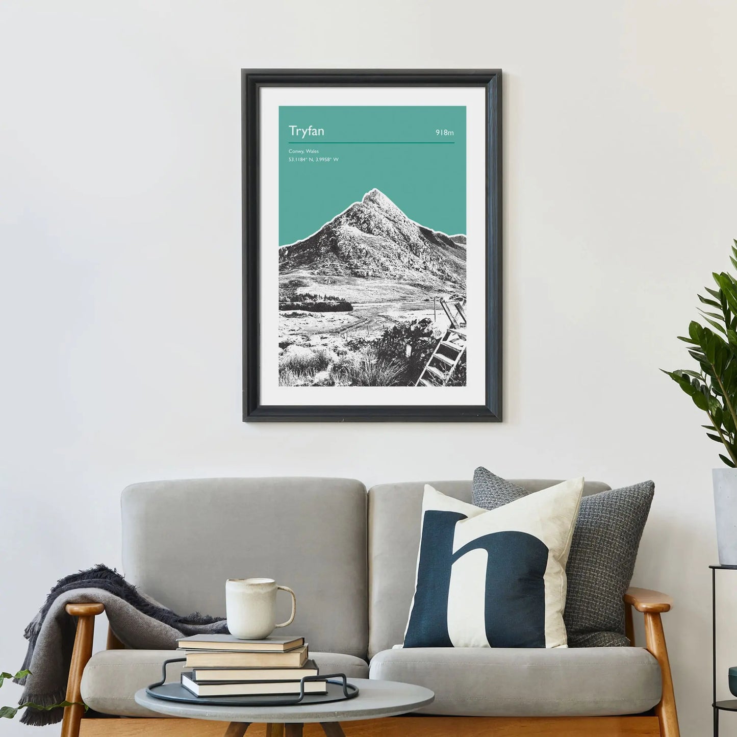 Print framed on wall above a sofa and cushions