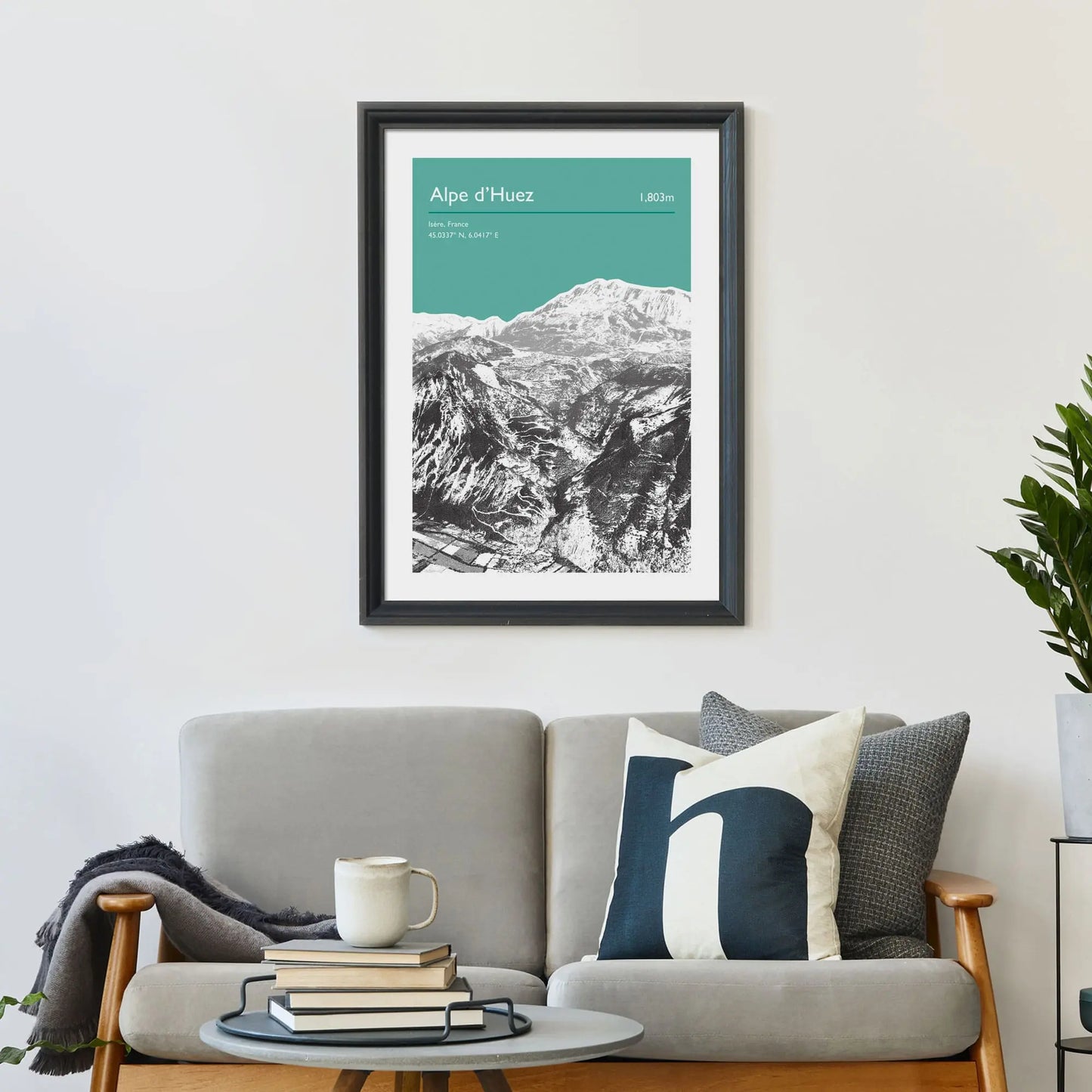 Print framed on wall above a sofa and cushions