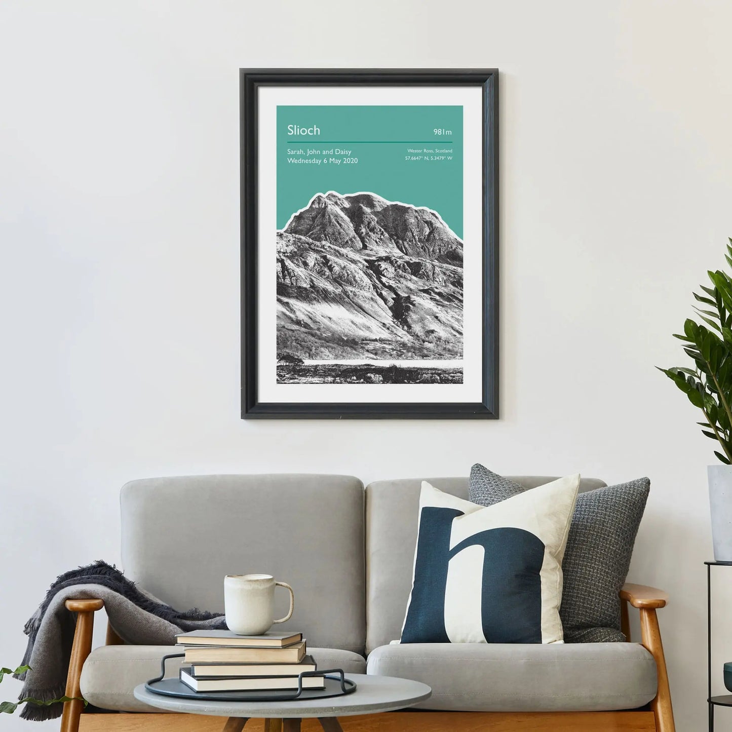 Print framed on wall above a sofa and cushions