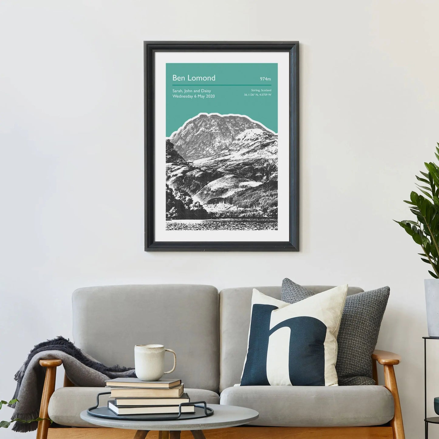 Print framed on wall above a sofa and cushions