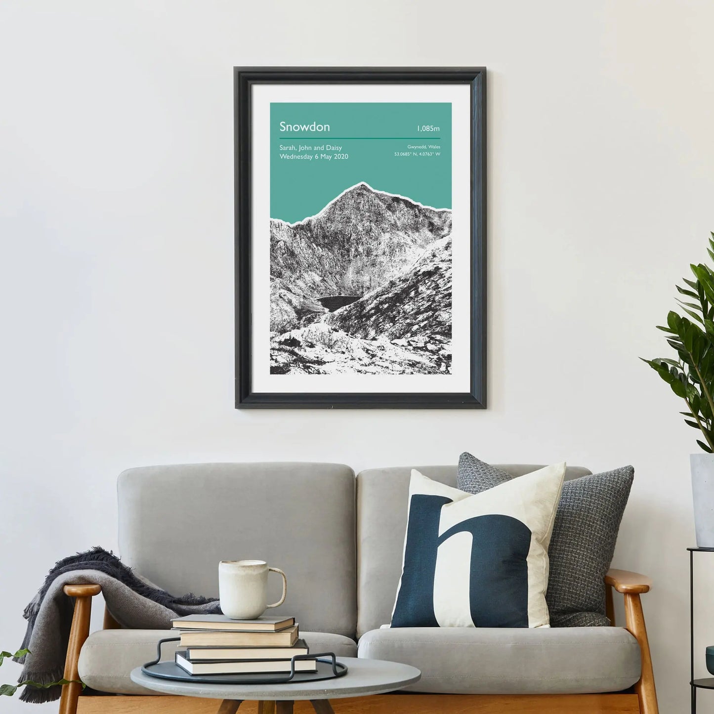 Print framed on wall above a sofa and cushions