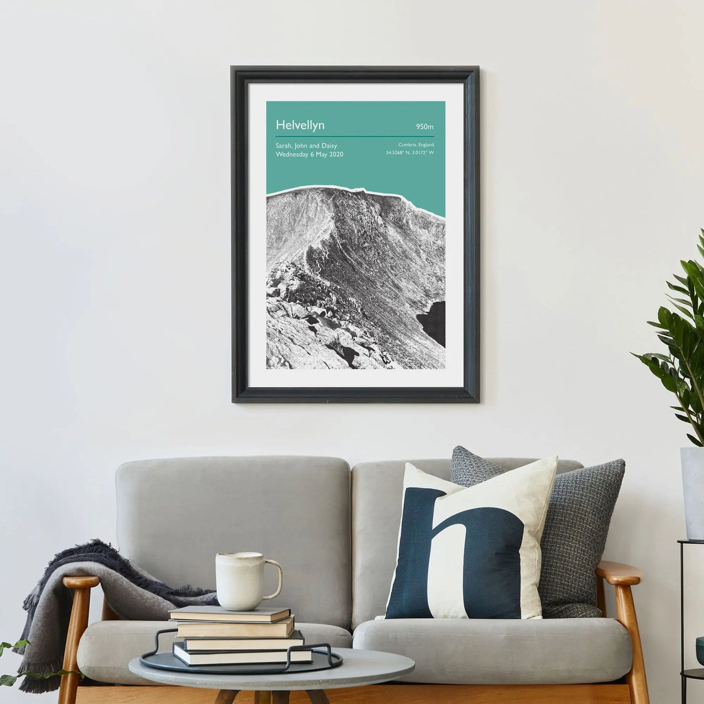 Print framed on wall above a sofa and cushions