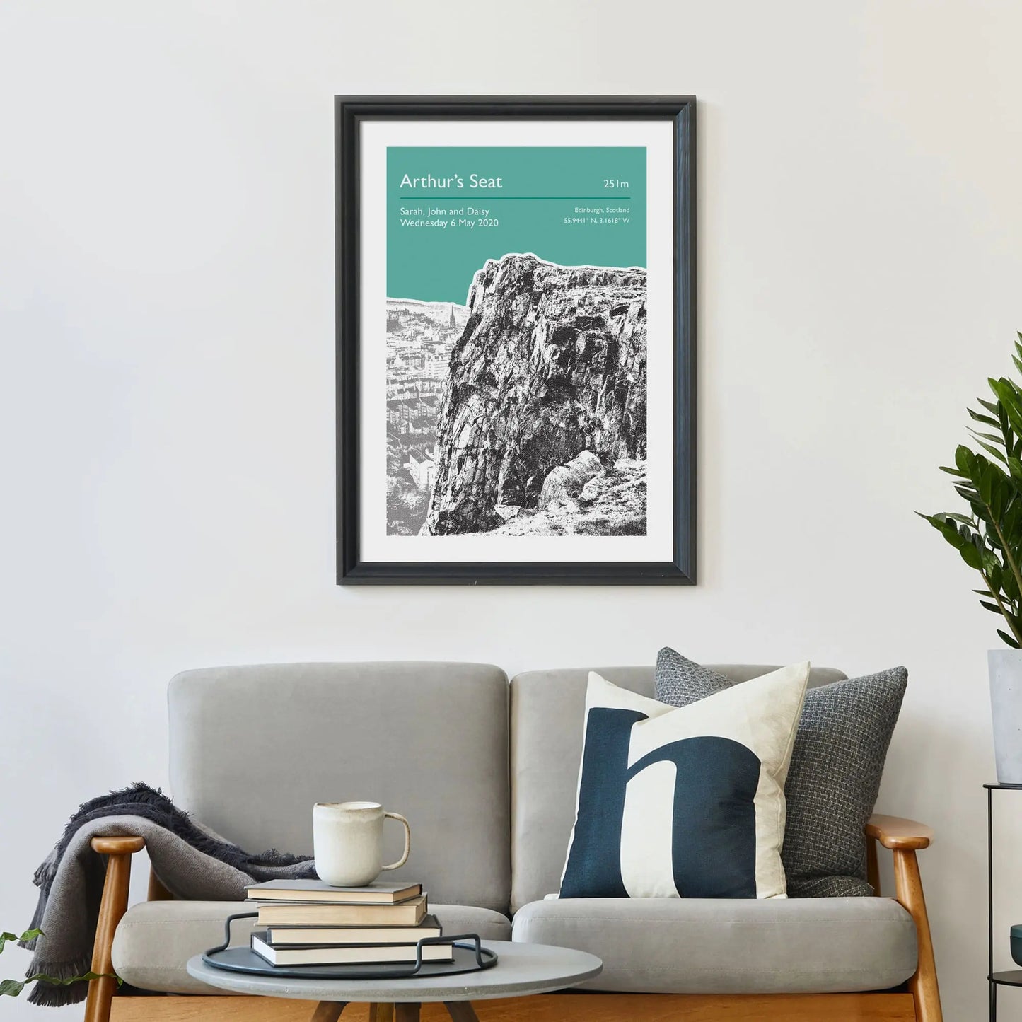 Print framed on wall above a sofa and cushions