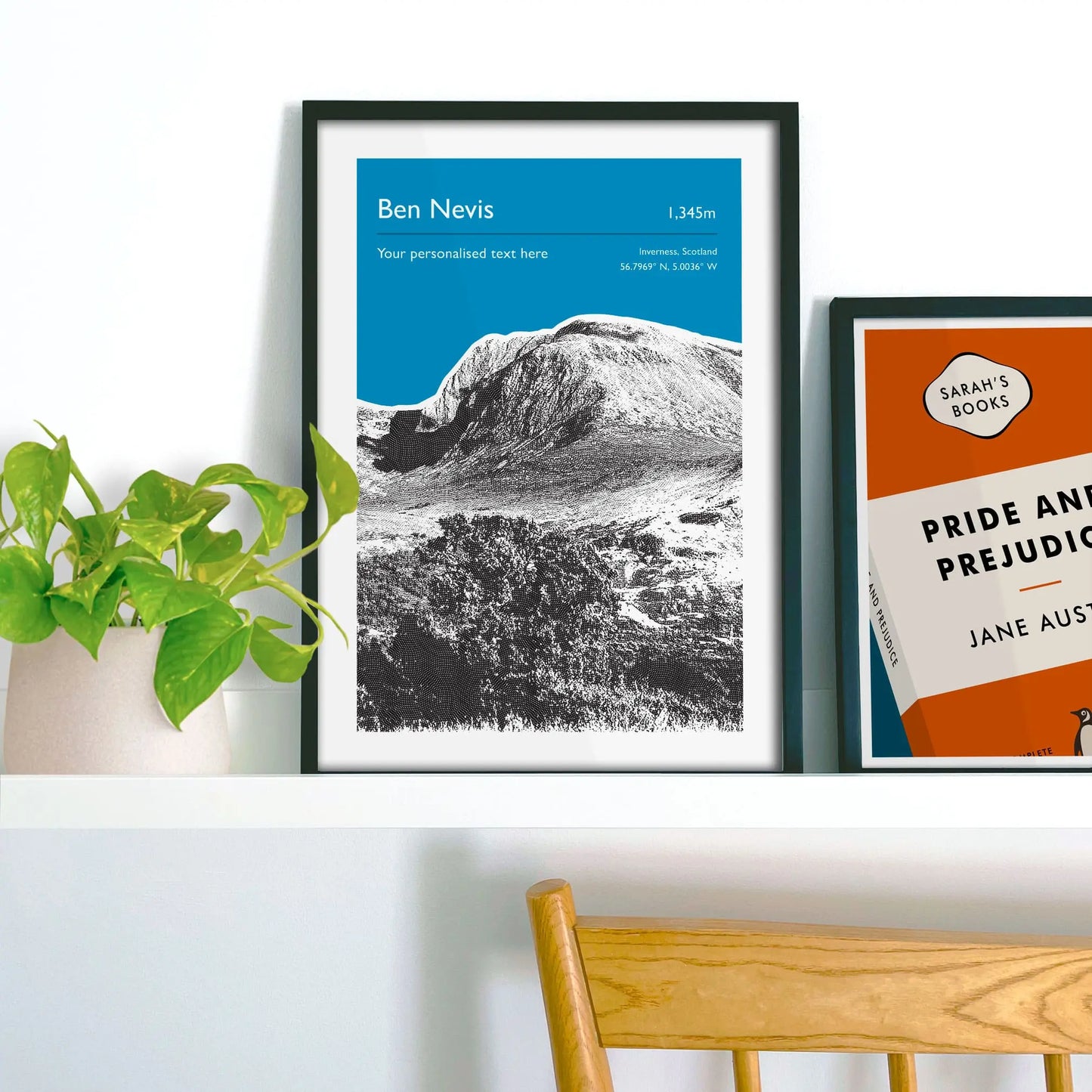 Framed picture on shelf beside a houseplant and another print. 