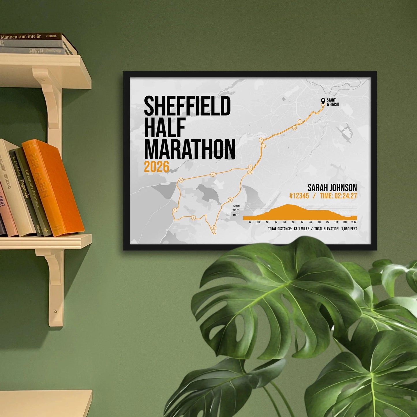 Print framed and in a black frame on a green wall beside some shelves