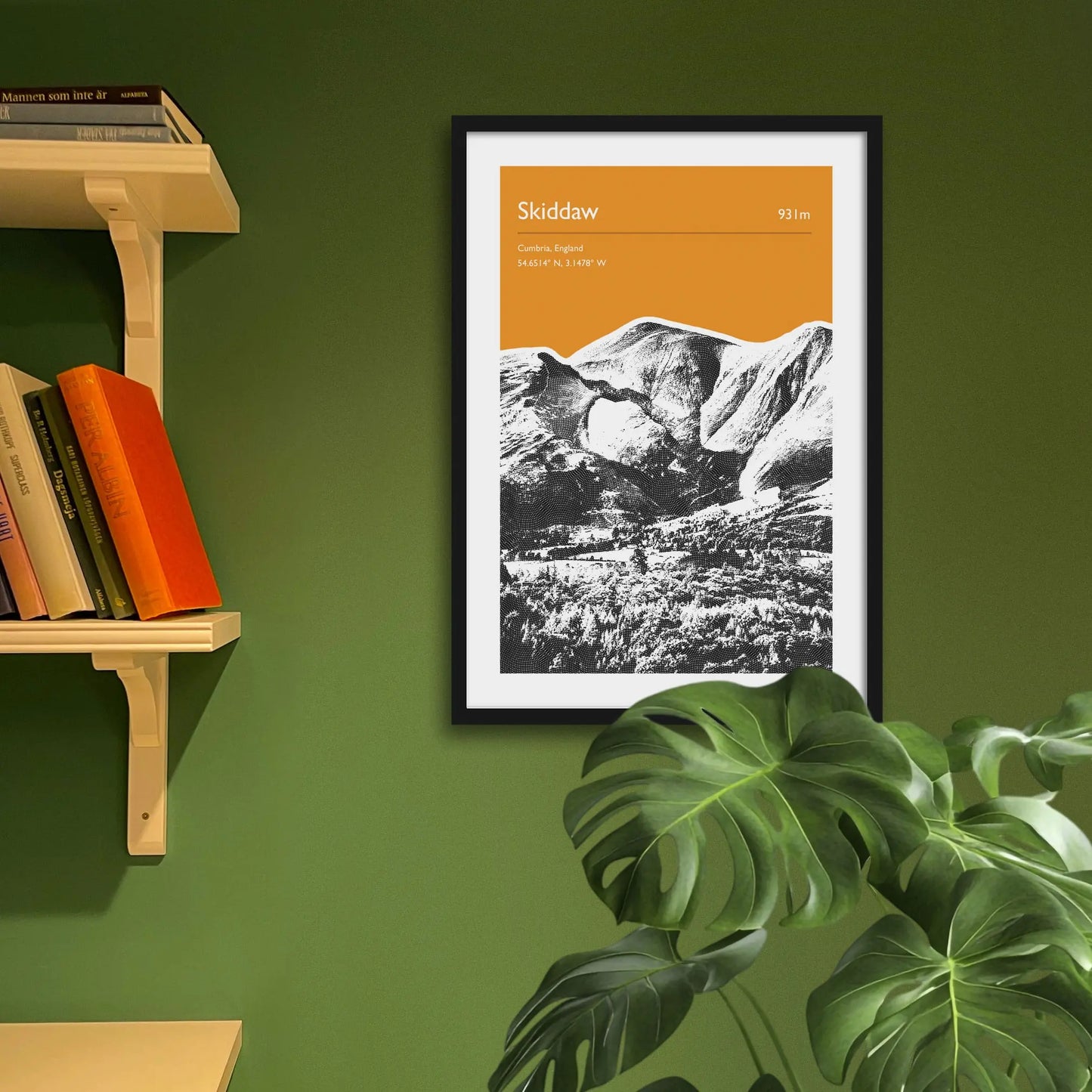 Framed art print on a green wall beside shelves.