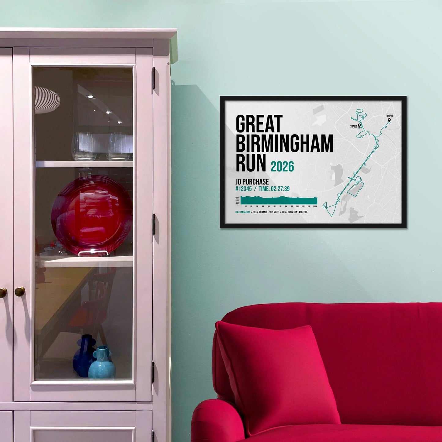 Framed picture on a baby blue wall beside pink shelving