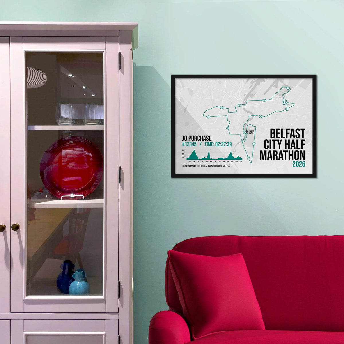 Framed picture on a baby blue wall beside pink shelving