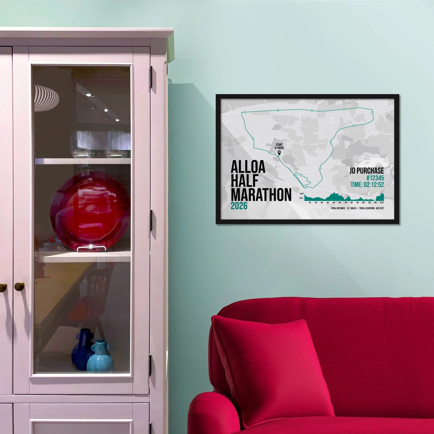 Framed picture on a baby blue wall beside pink shelving
