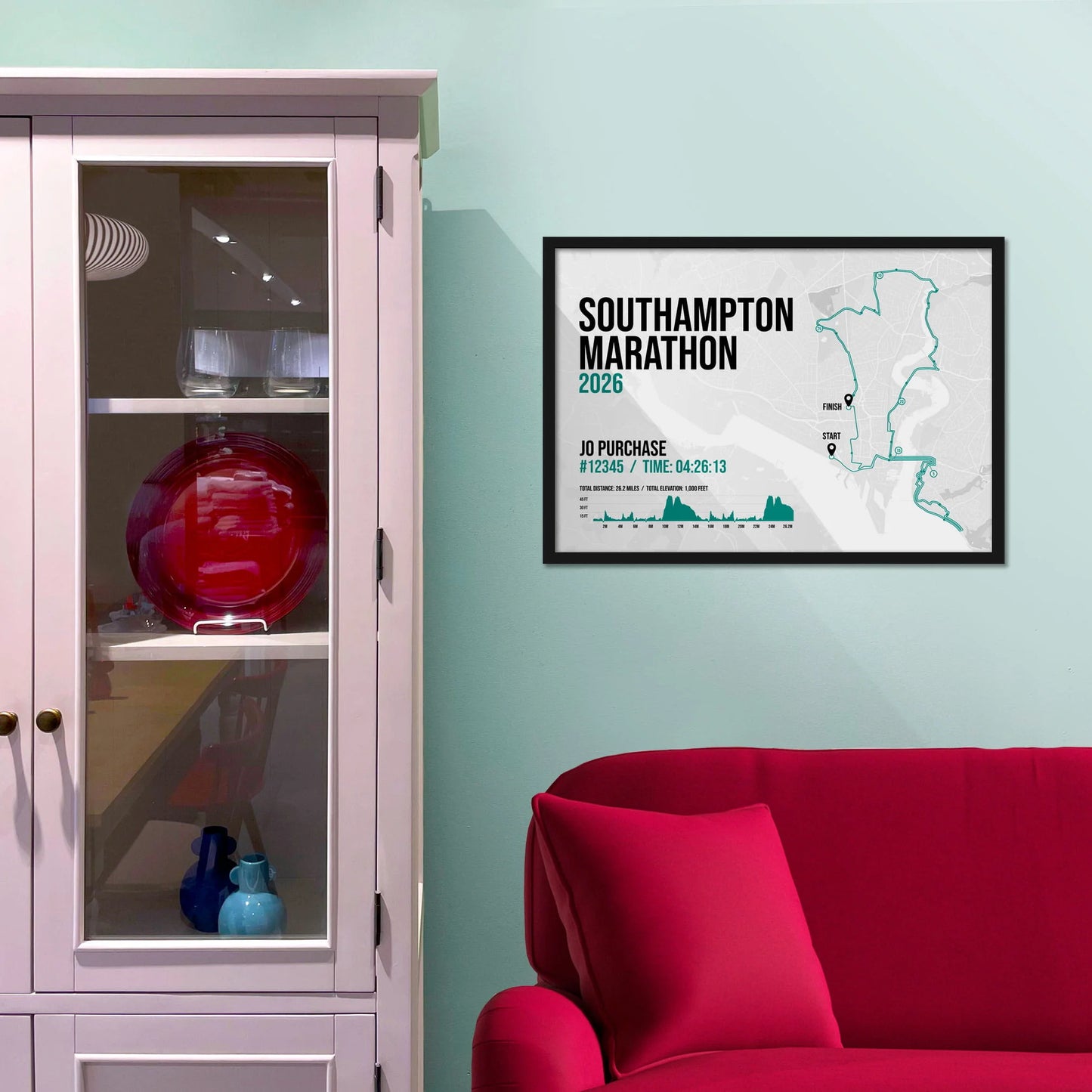 Framed picture on a baby blue wall beside pink shelving