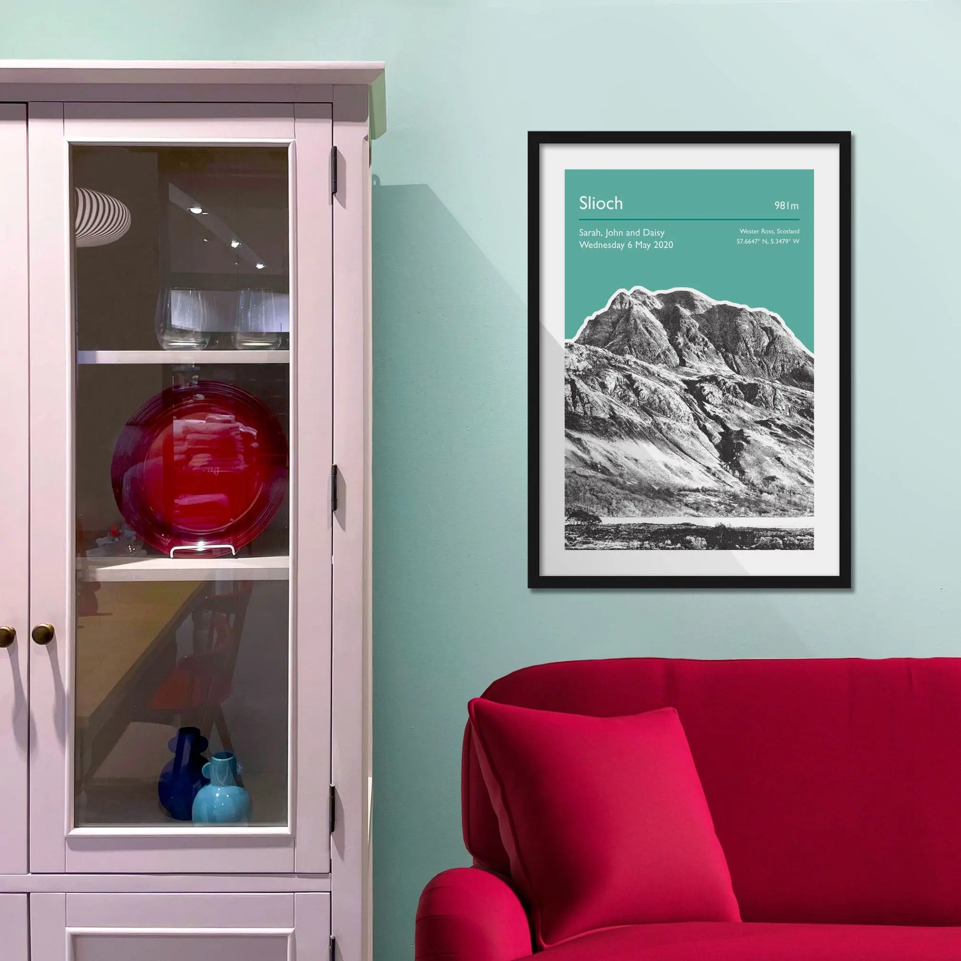 Framed picture on a baby blue wall beside pink shelving