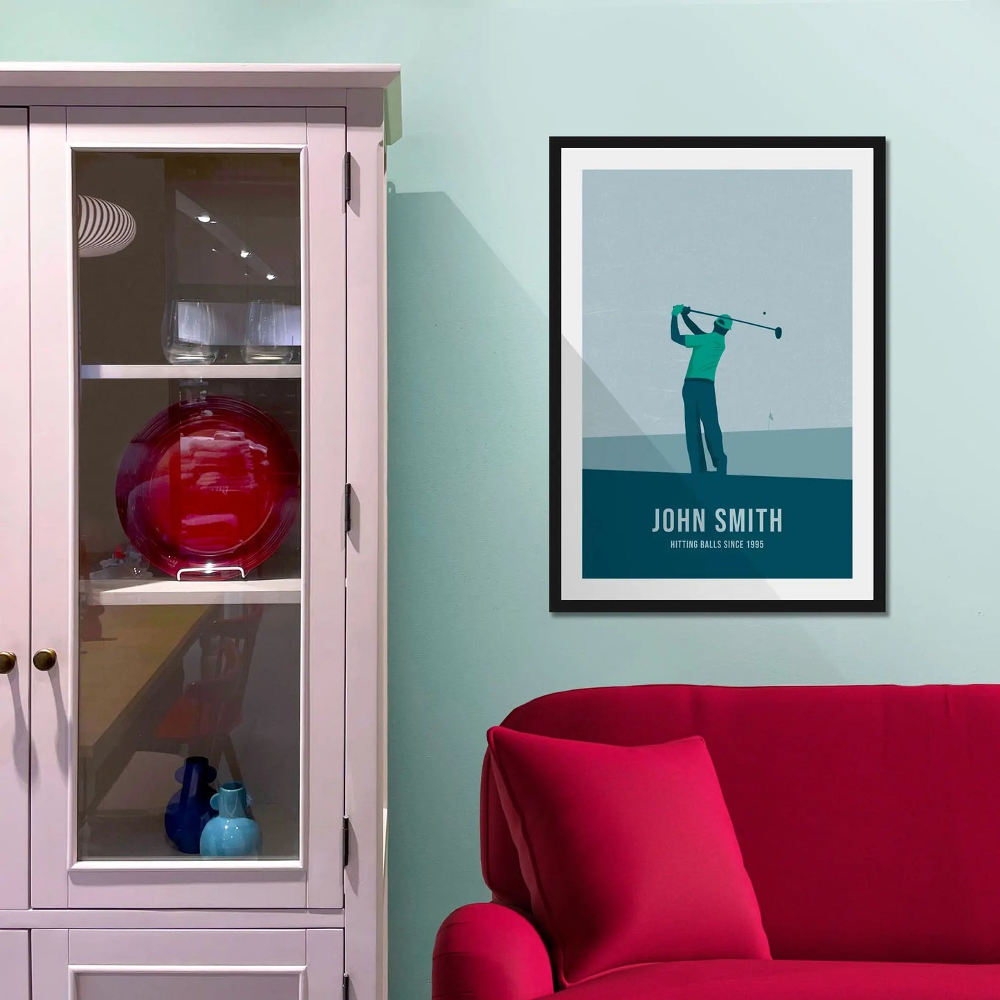 Framed picture on a baby blue wall beside pink shelving