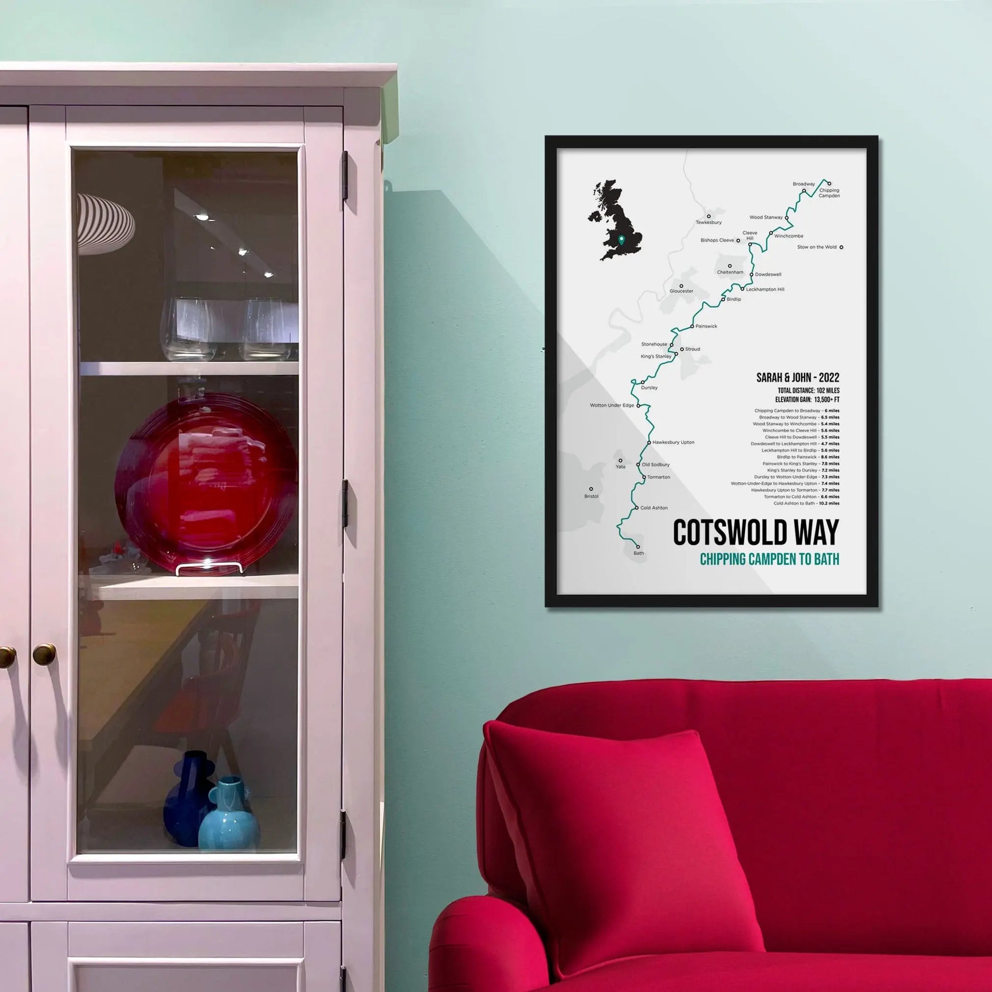 Framed print on blue wall beside shelving above a red sofa