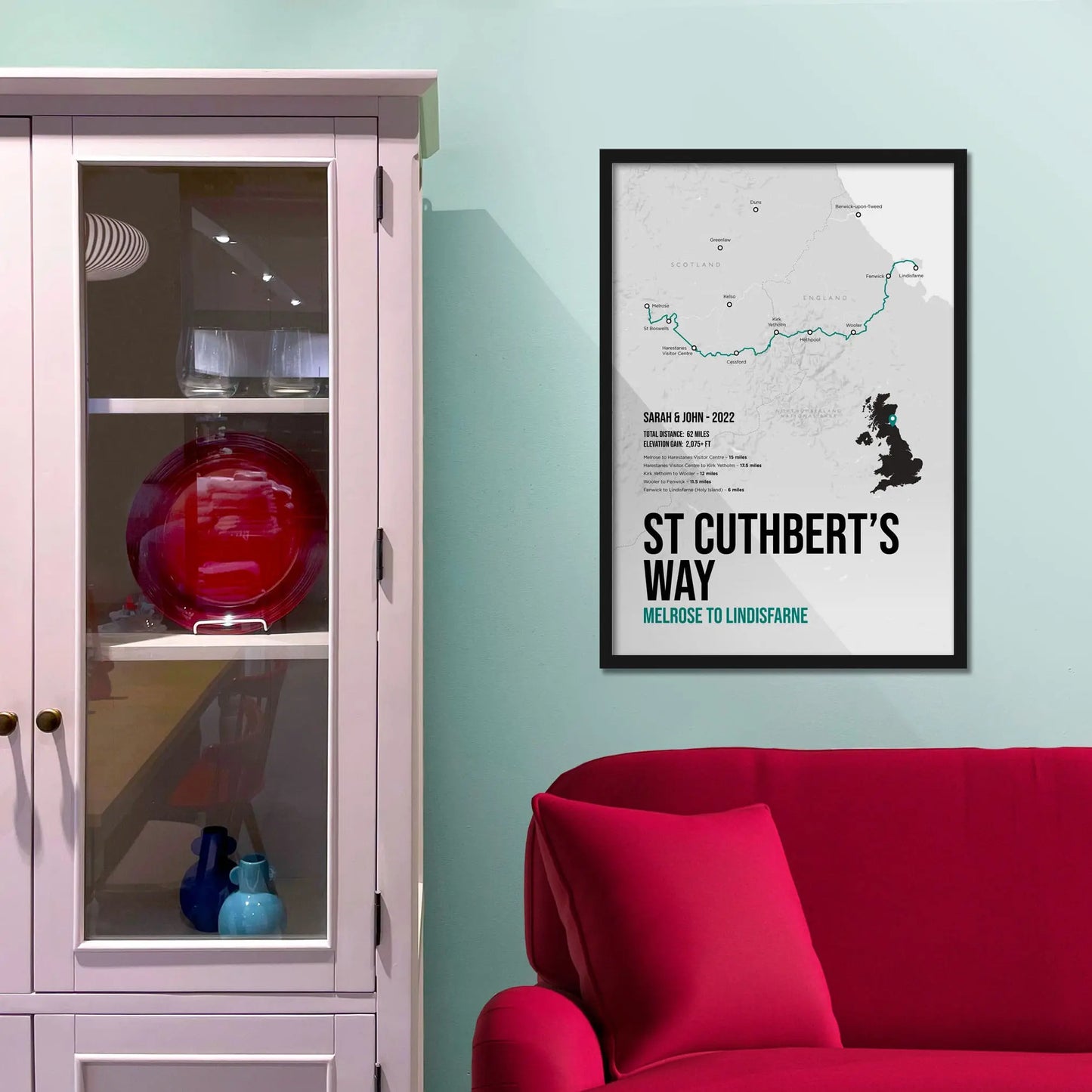 Framed print on light blue wall beside pink shelving unit.