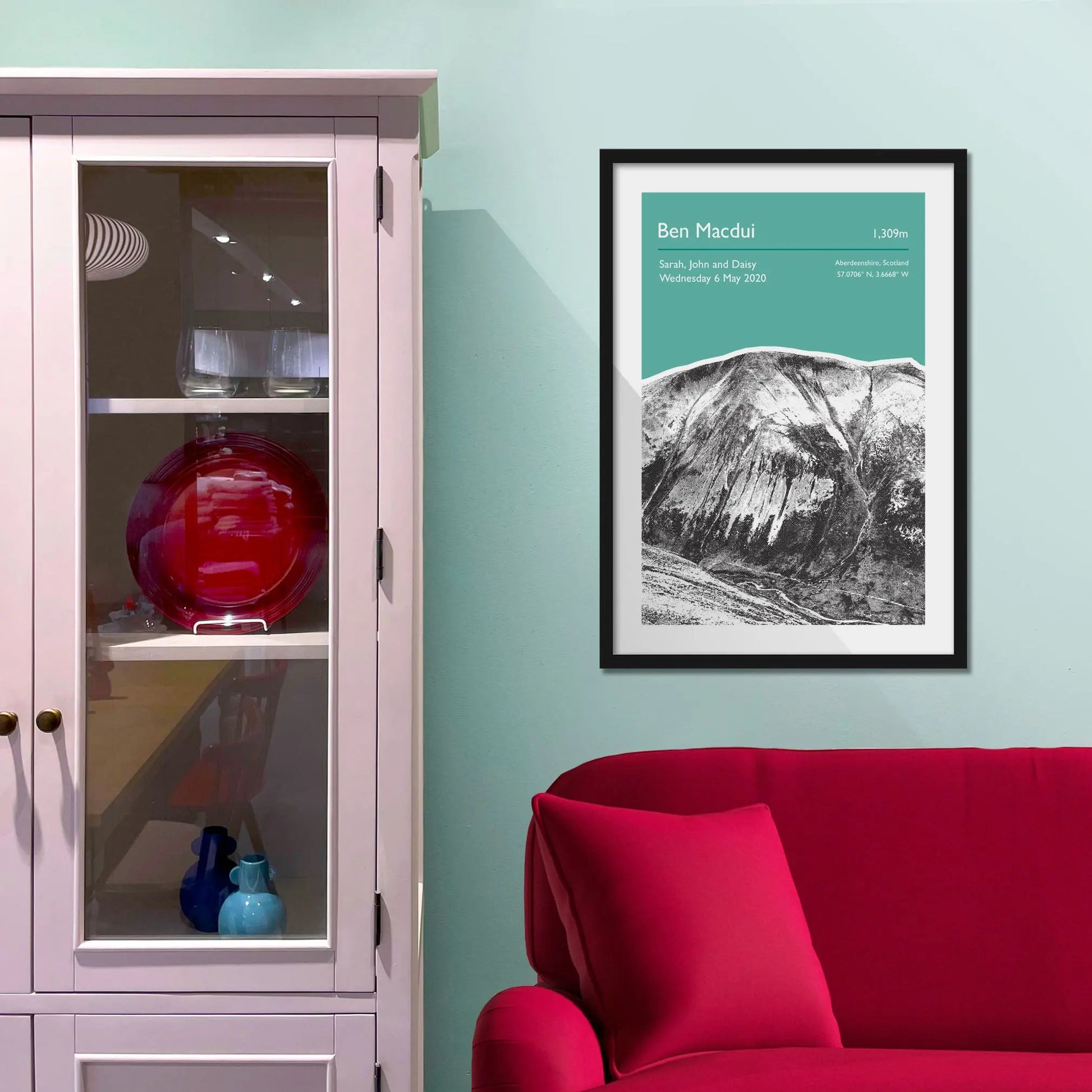 Framed picture on a baby blue wall beside pink shelving