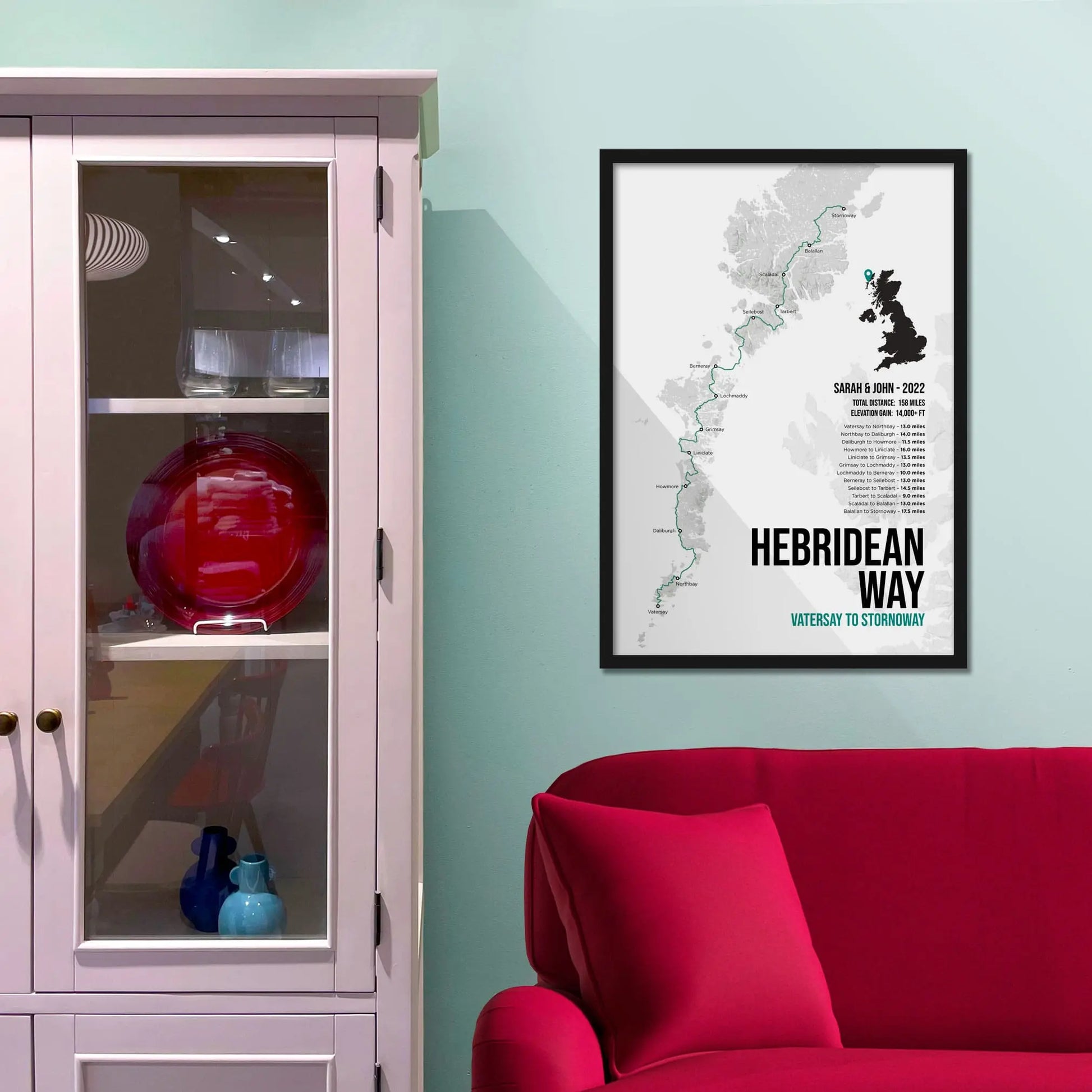 Framed print on light blue wall beside pink shelving unit.