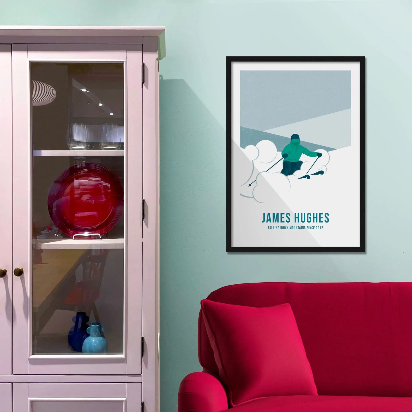 Framed picture on a baby blue wall beside pink shelving