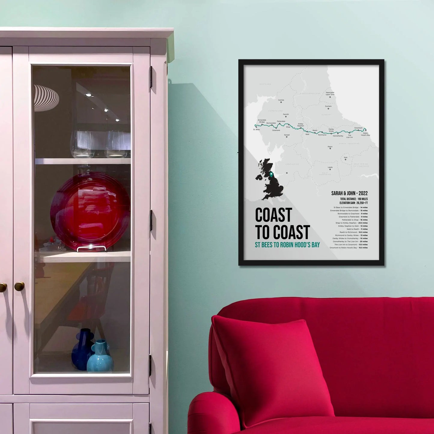 Framed print on blue wall beside shelving unit above a red sofa