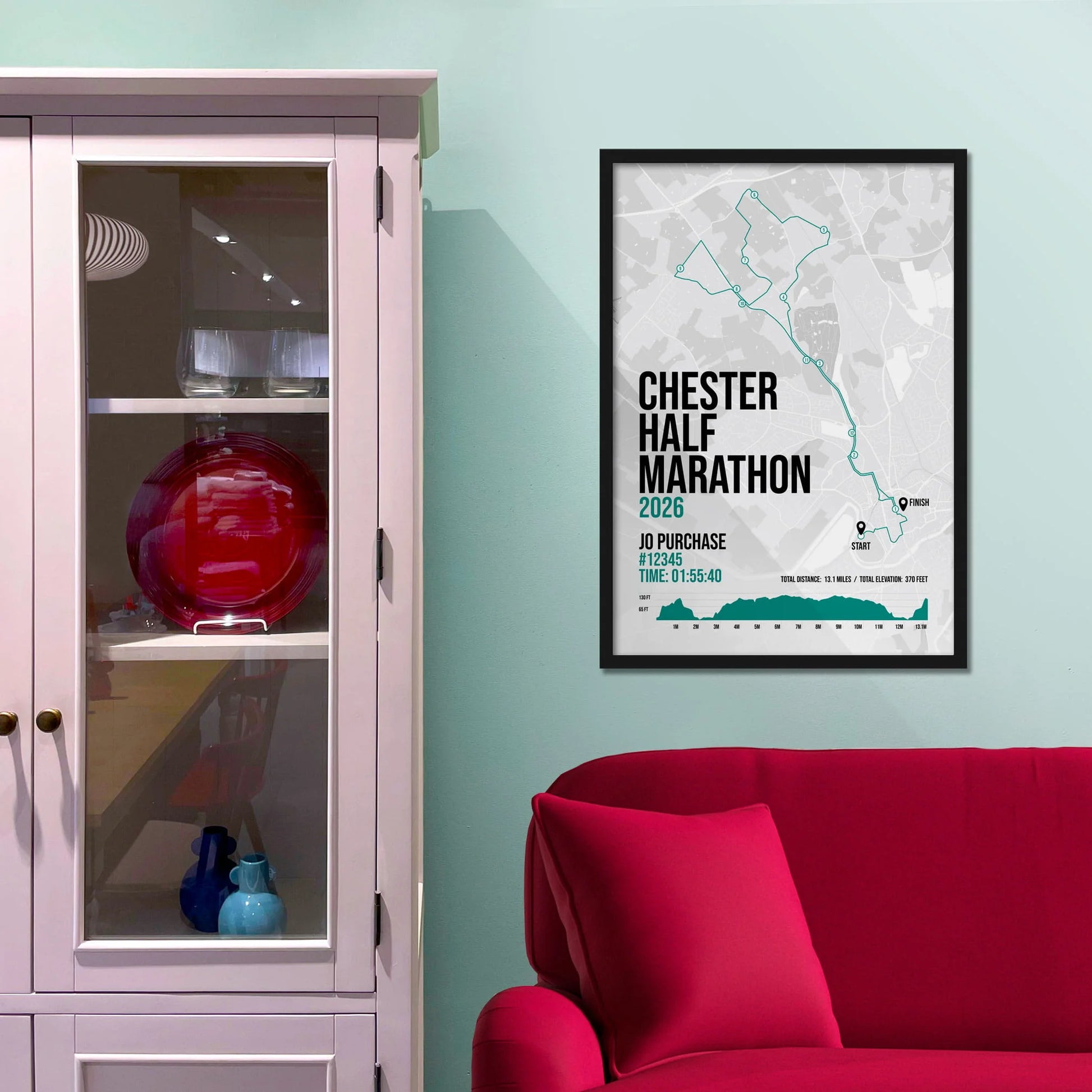 Framed picture on a baby blue wall beside pink shelving