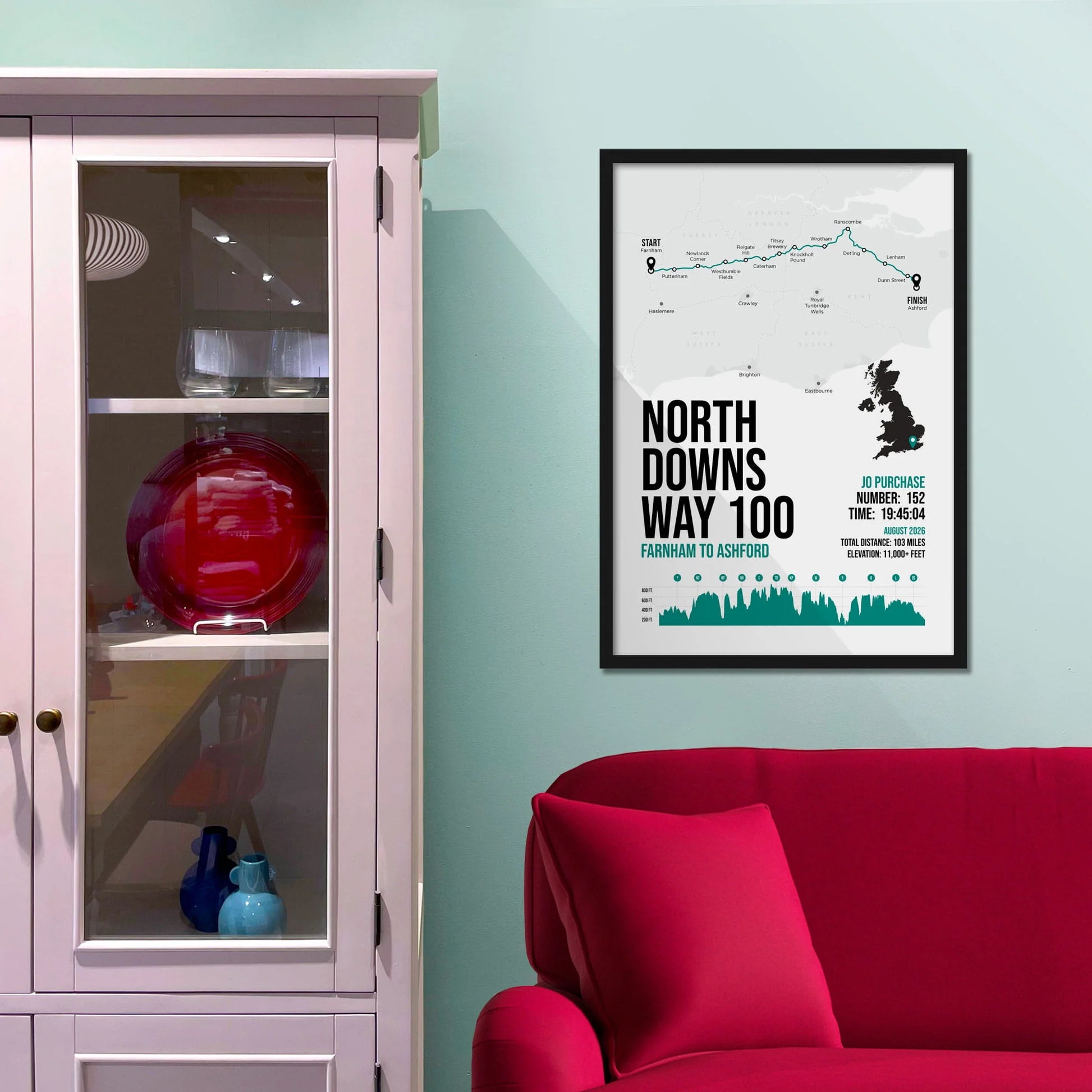 Framed picture on a baby blue wall beside pink shelving