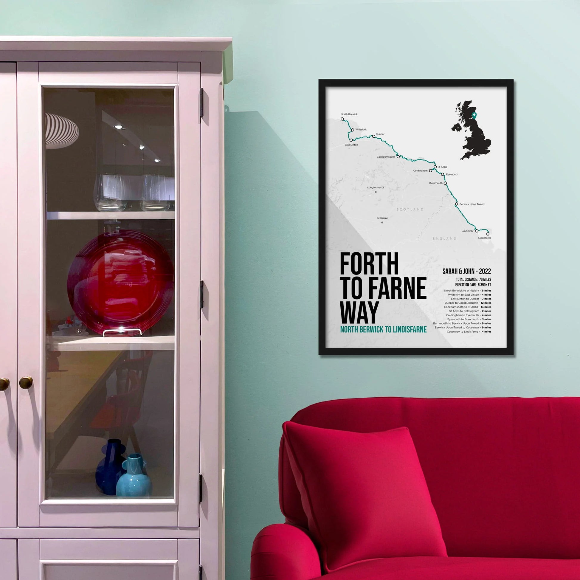 Framed print on light blue wall beside pink shelving unit.