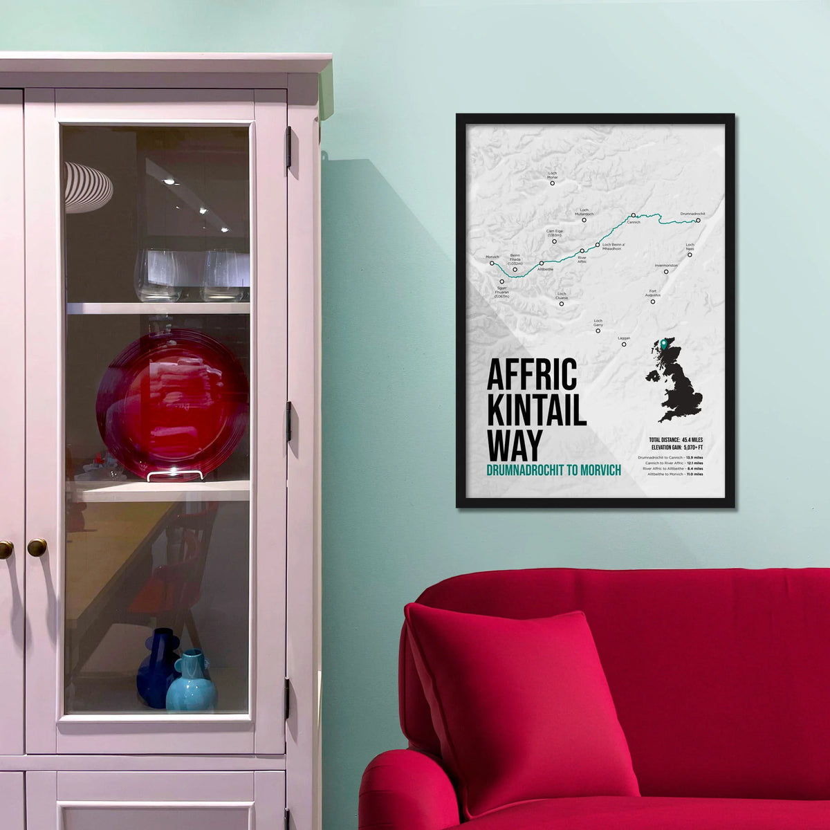 Framed print on light blue wall beside pink shelving unit.