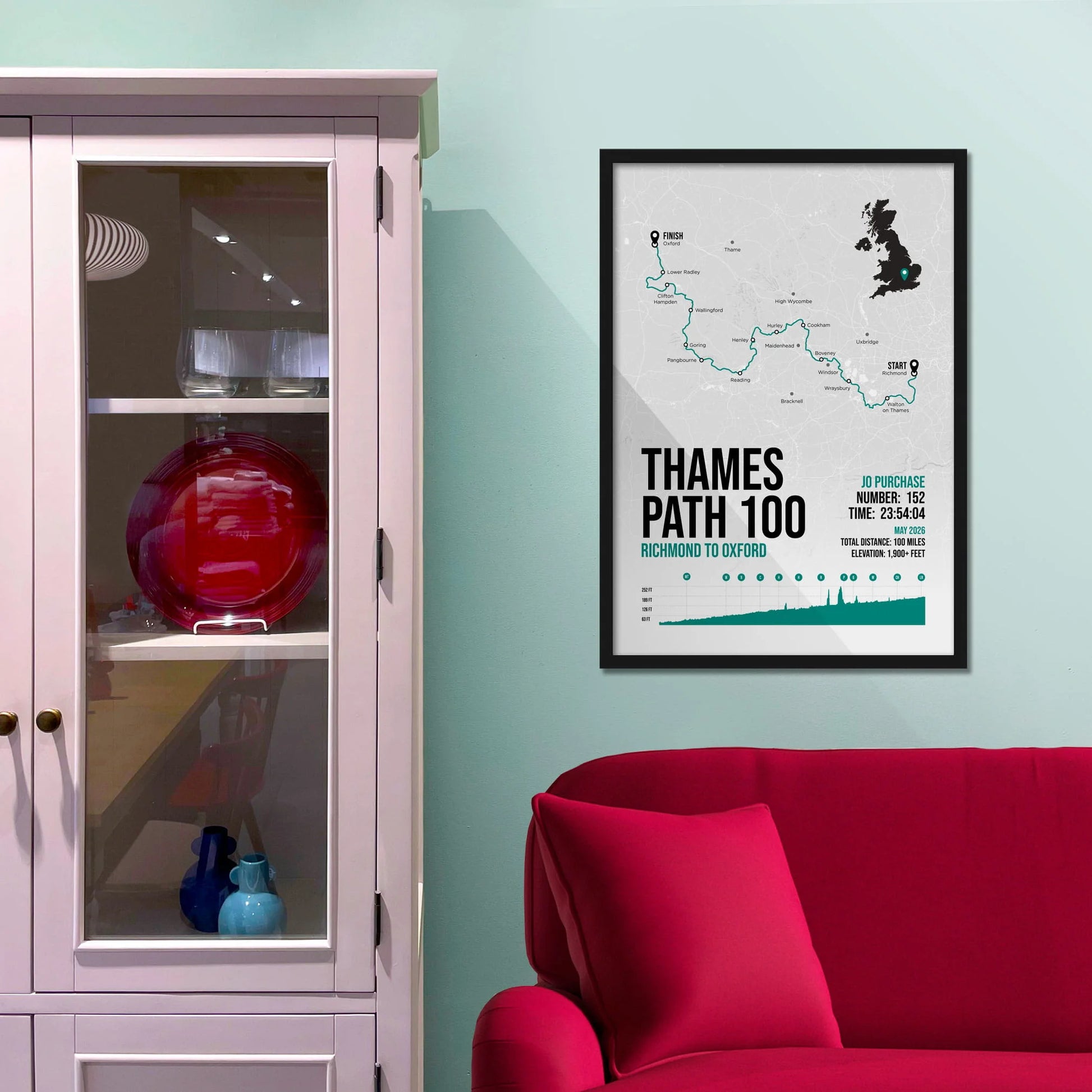 Framed picture on a baby blue wall beside pink shelving