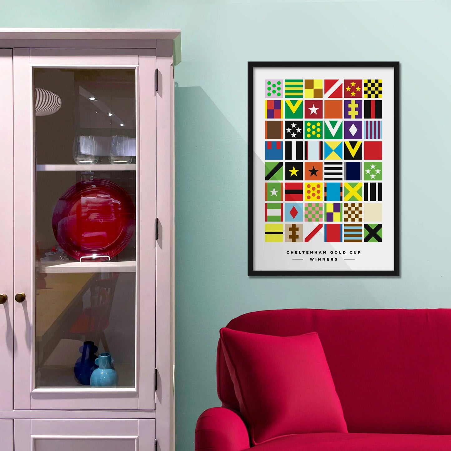 Framed picture on a baby blue wall beside pink shelving