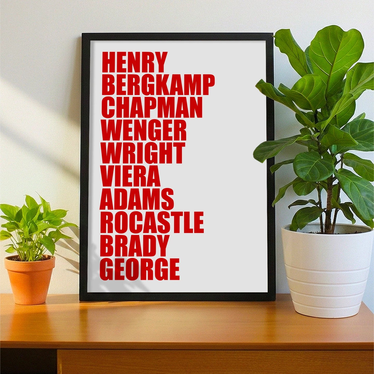 Framed print on sideboard beside a plant