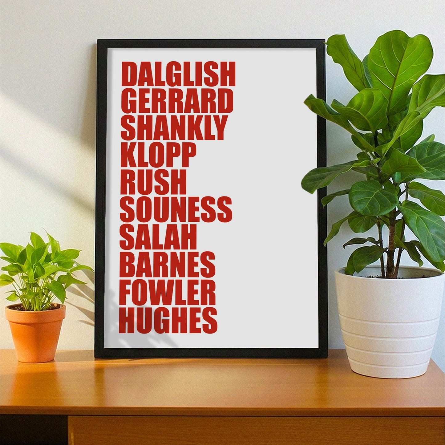 Framed print on sideboard beside a plant