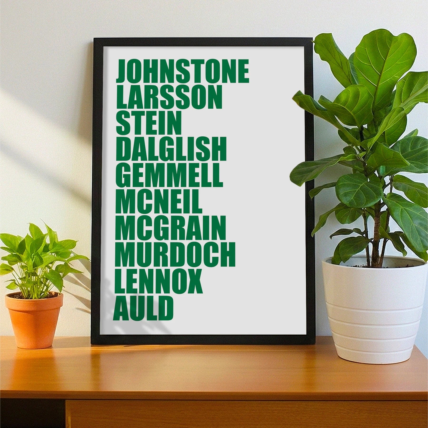 Framed print on sideboard beside a plant