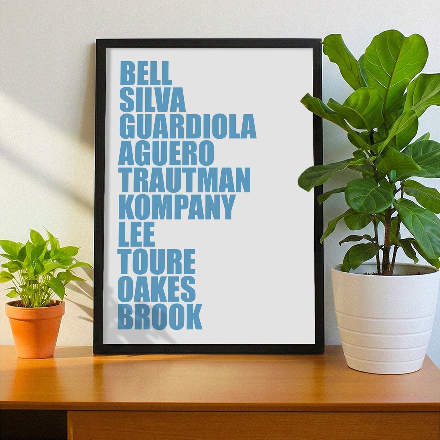 Framed print on sideboard beside a plant