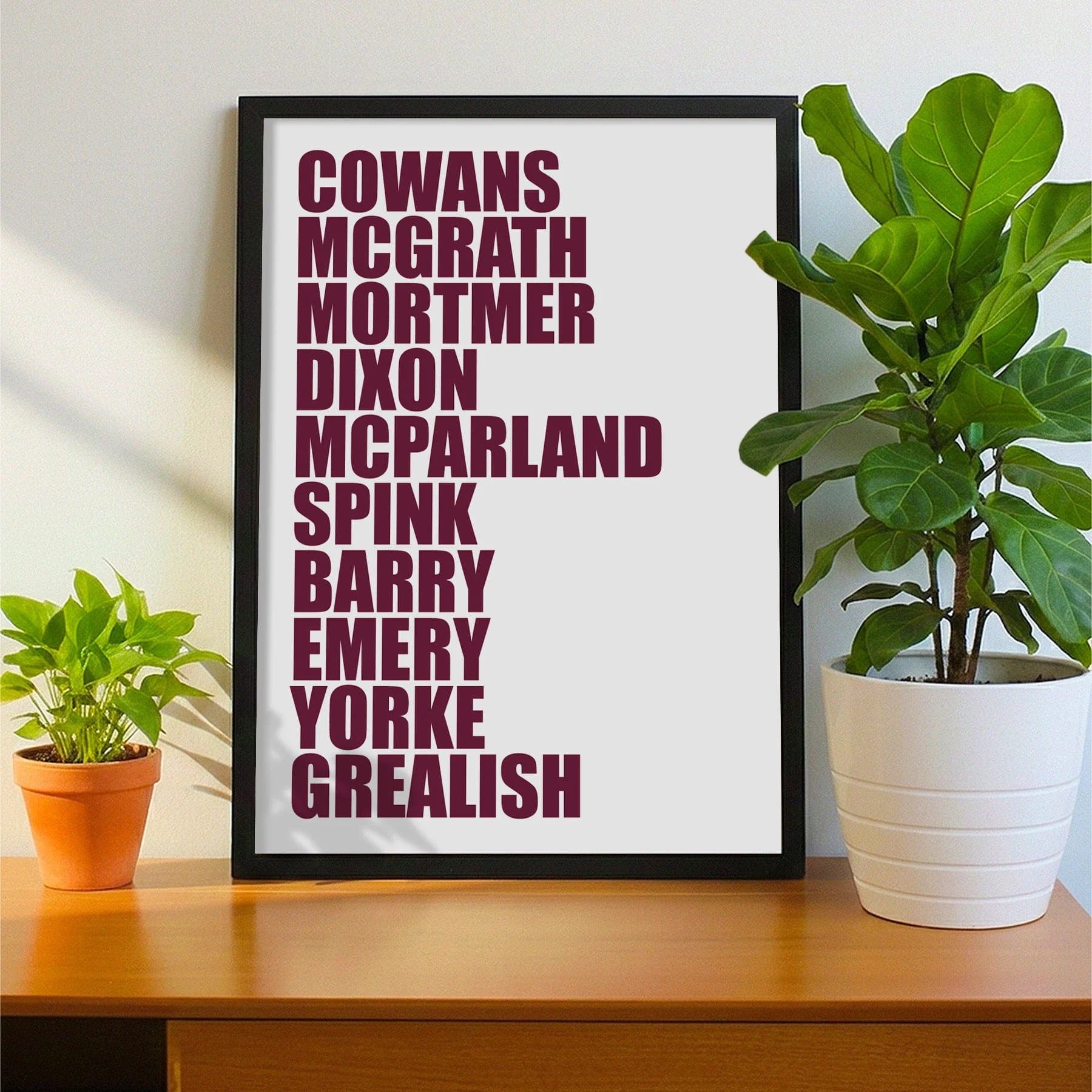 Framed print on sideboard beside a plant