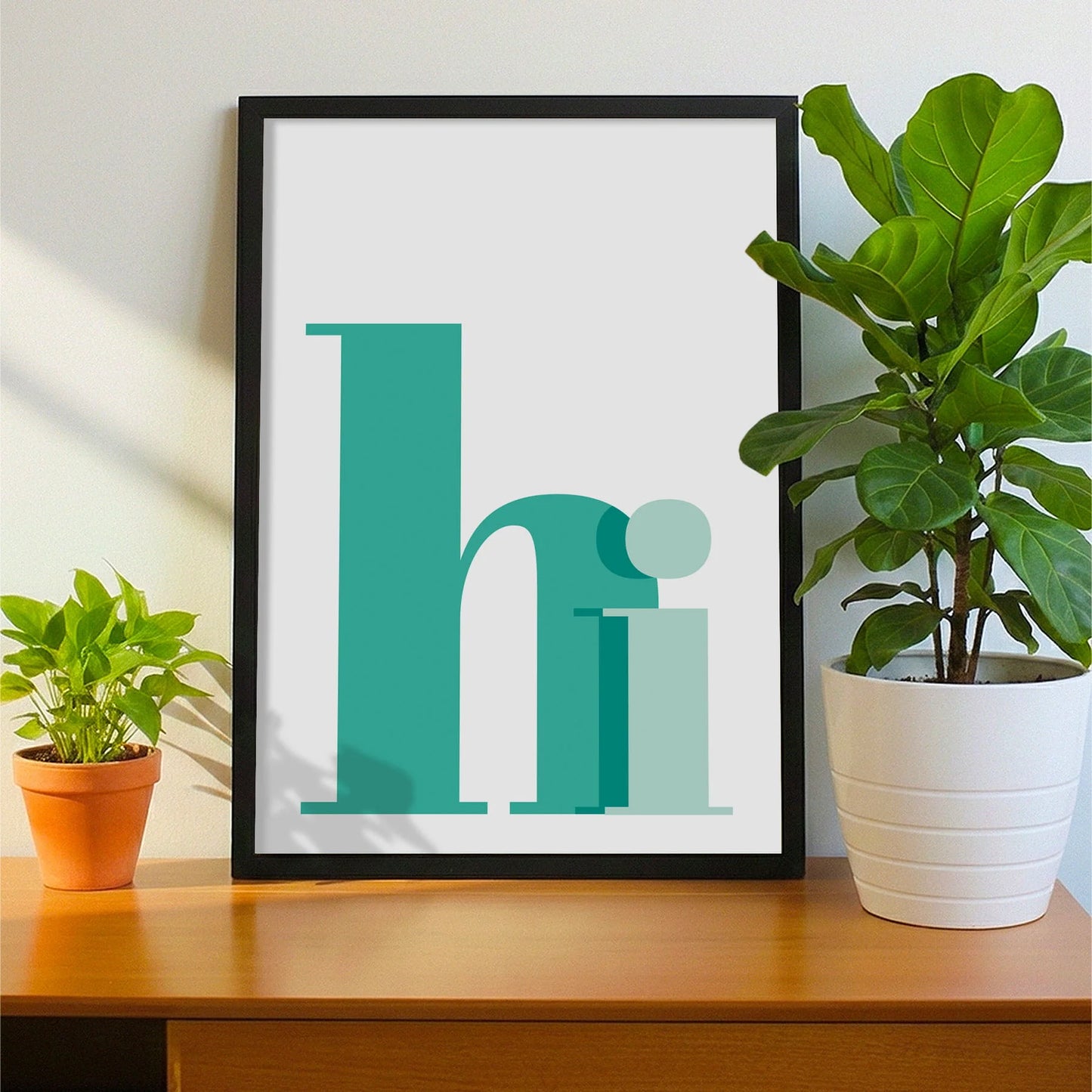 Framed print on sideboard beside a plant