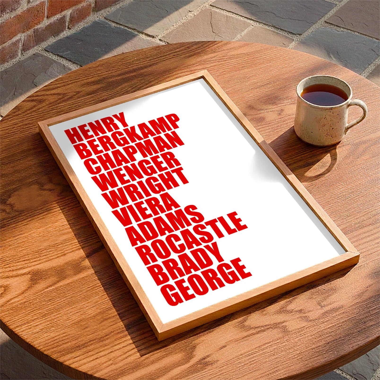 Framed print laying on a table beside a mug of tea
