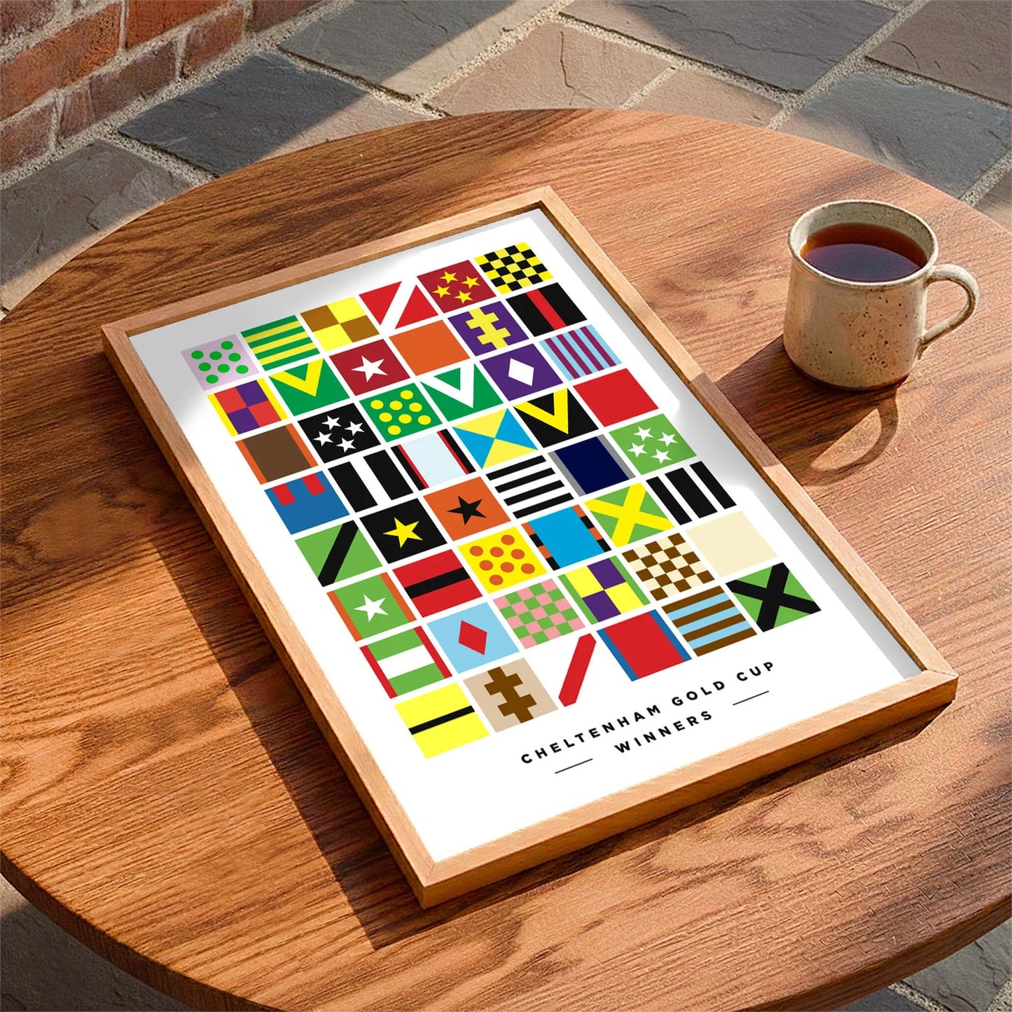 Framed print laying on a coffee table beside a mug of tea