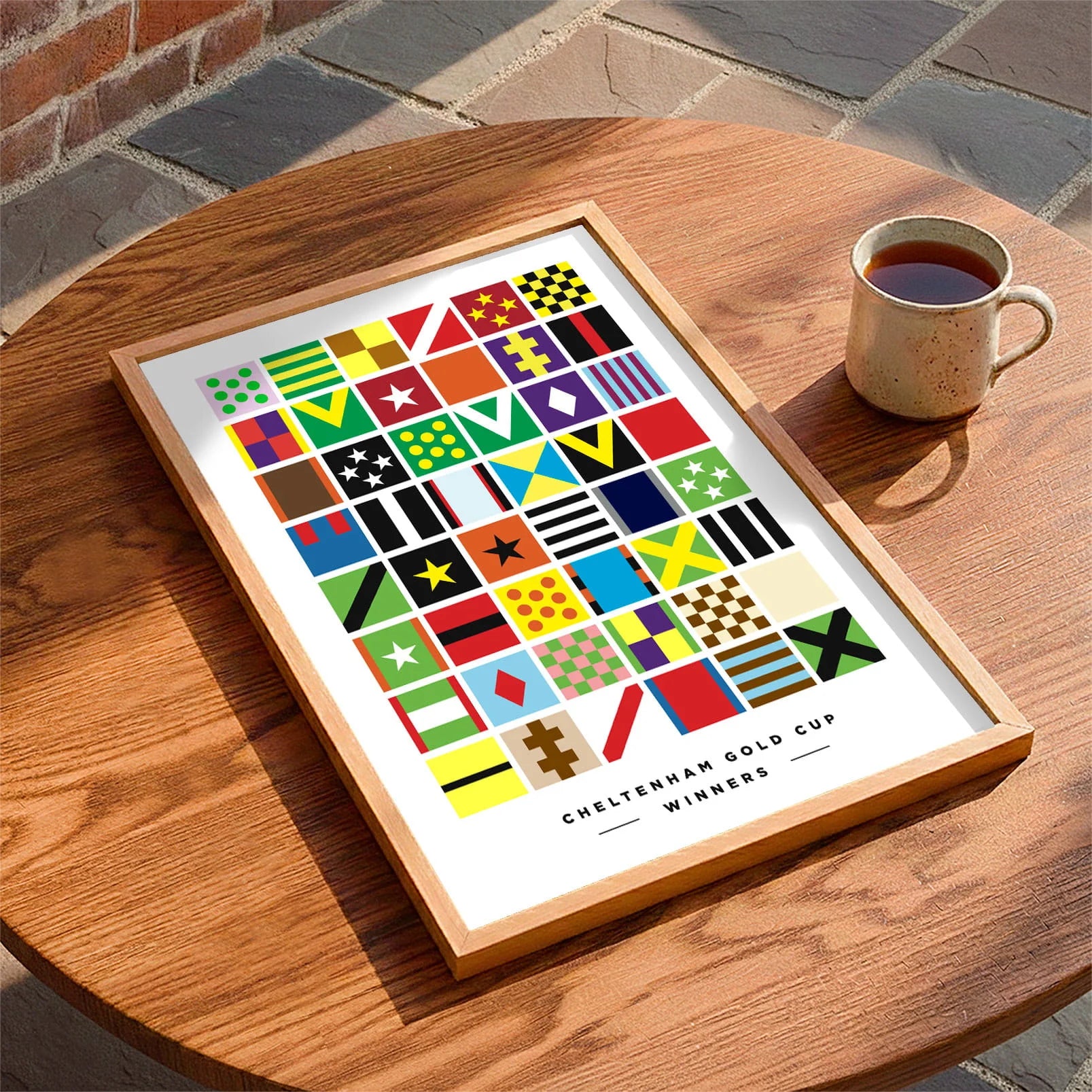 Framed print laying on a coffee table beside a mug of tea