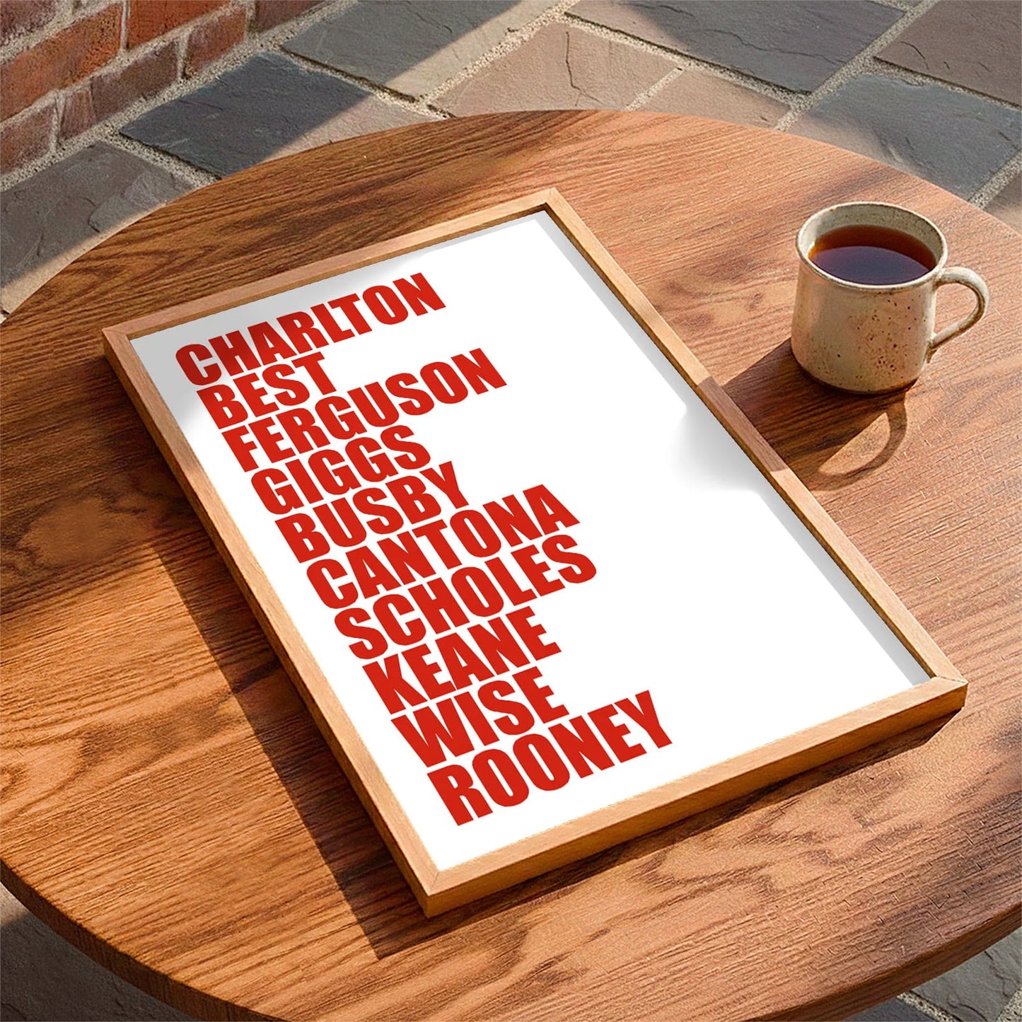 Framed print laying on a table beside a mug of tea