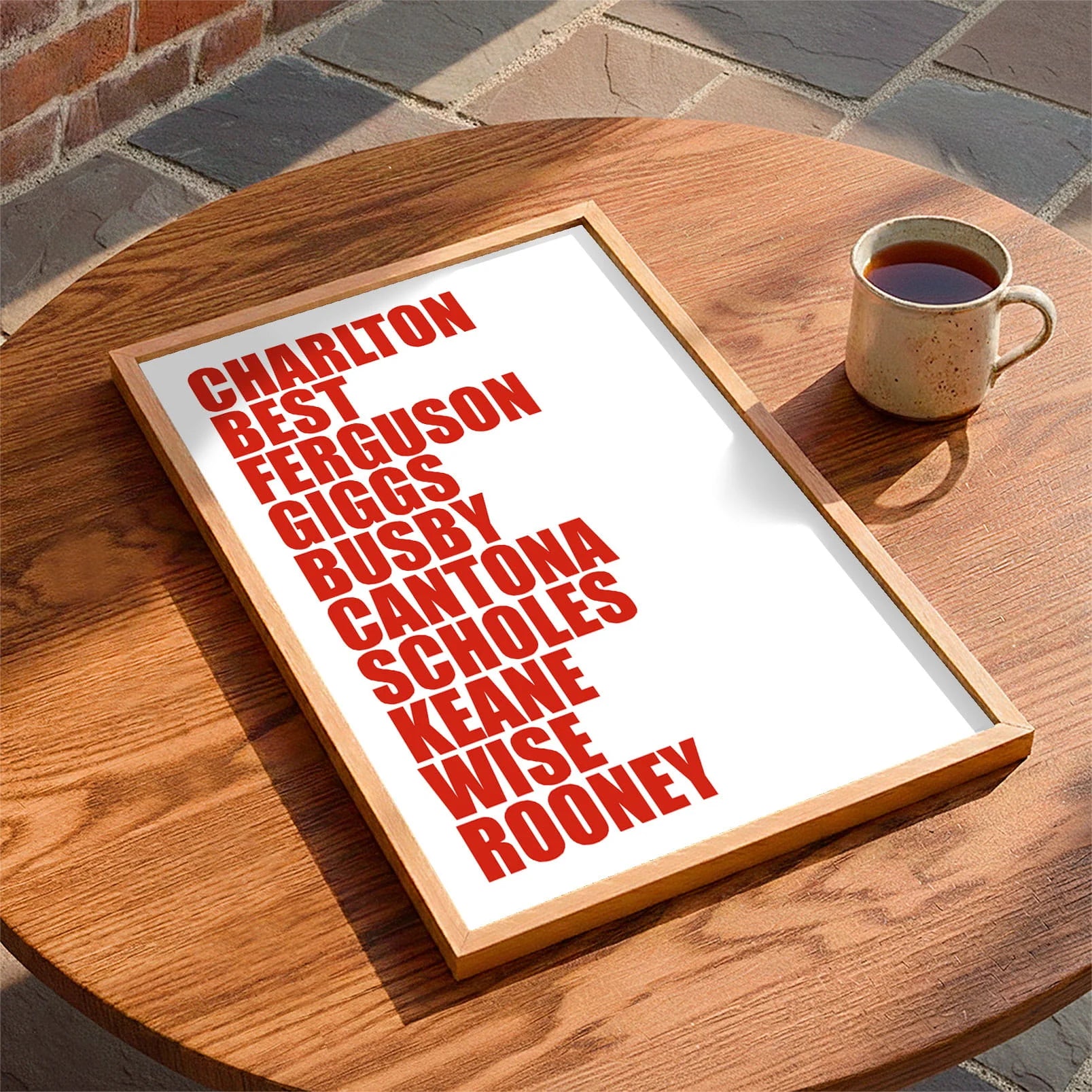 Framed print laying on a table beside a mug of tea