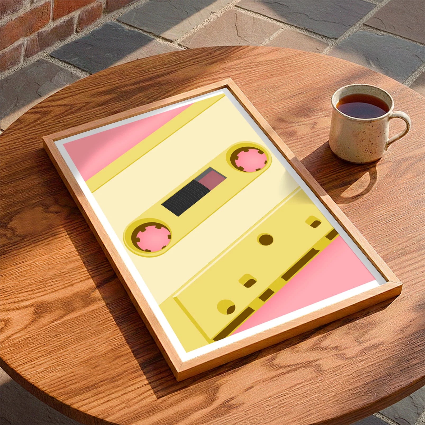 Framed print laying on a table beside a mug of tea