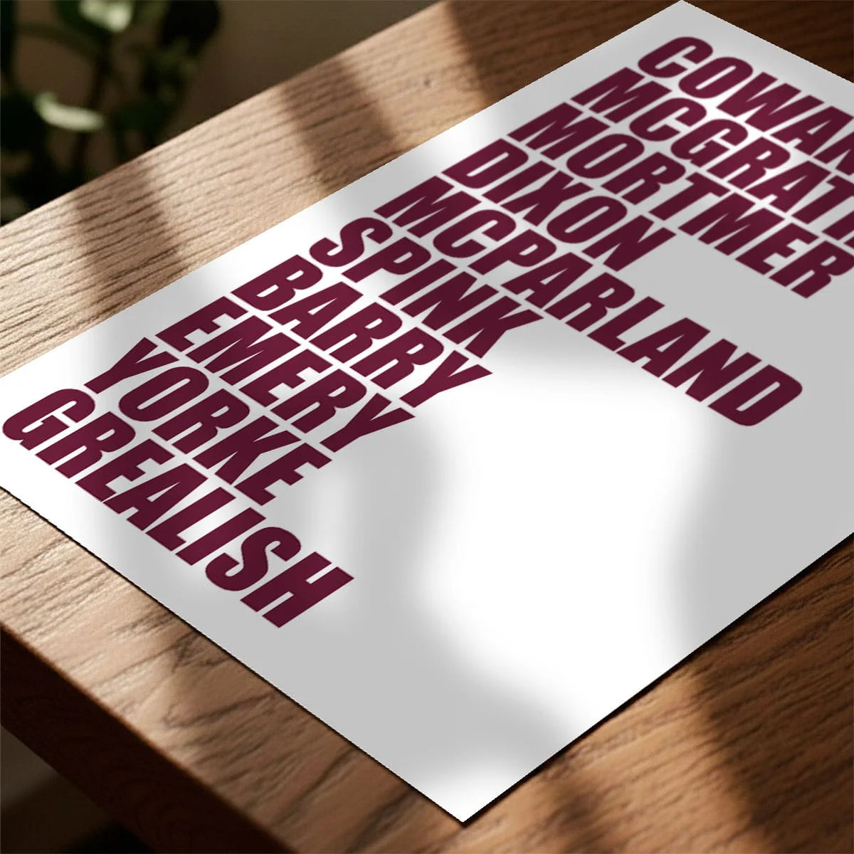 Print laying on table with speckled shade cast across the surface