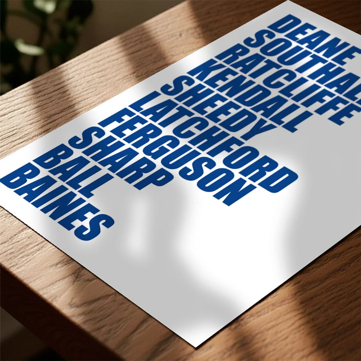 Print laying on table with speckled shade cast across the surface