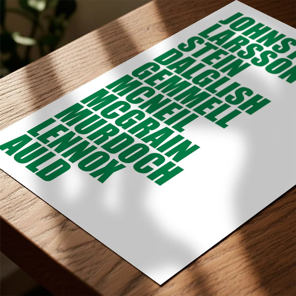 Print laying on table with speckled shade cast across the surface
