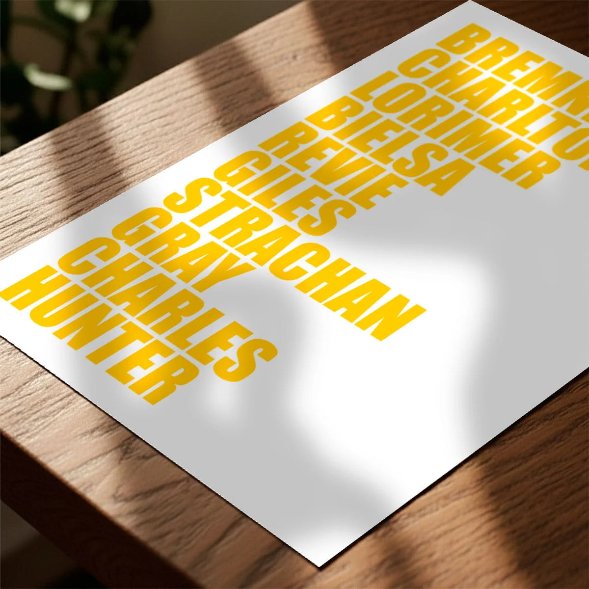 Print laying on table with speckled shade cast across the surface