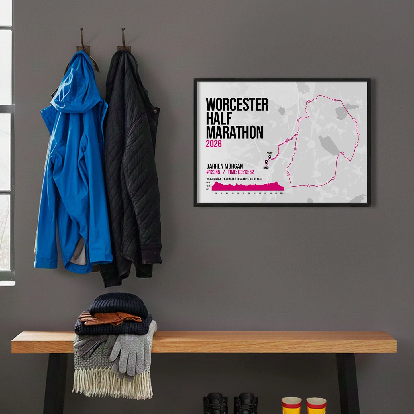 Framed print hanging on grey wall beside coats on hooks above walking boots and shows